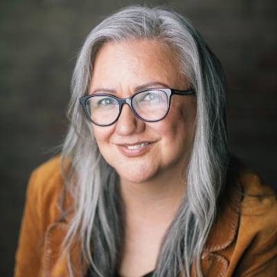 Dr. Cheryl Bear brown jacket and black background